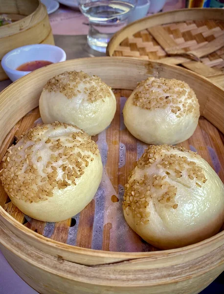 Chinese steamed bun in traditional bamboo steamer.  Chinese Steamed Pork Buns.
