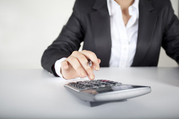 Woman’s fingers are on the calculator keys-Horizontal