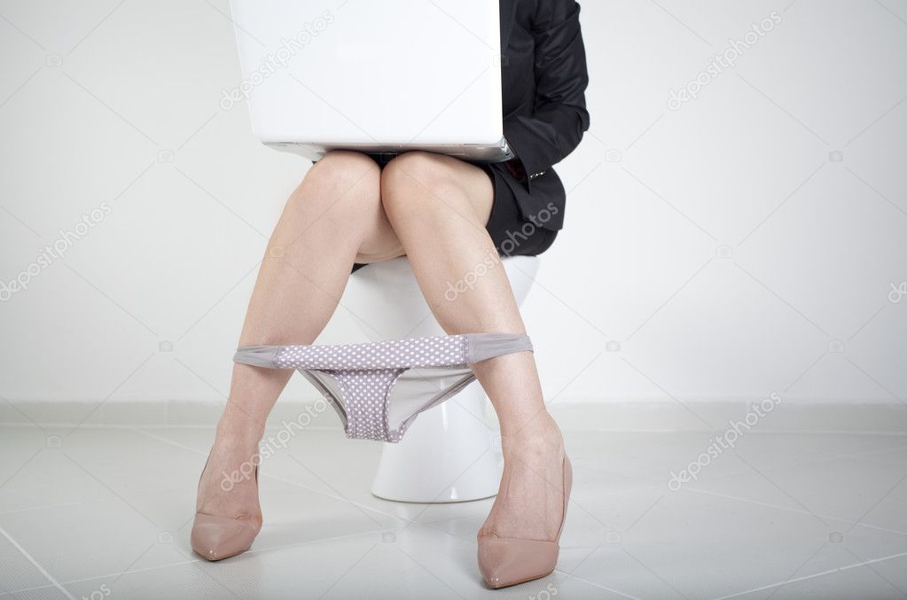 Woman working with computer in bathroom