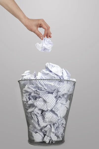 Femme jetant à la main du papier froissé dans une poubelle en argent — Photo