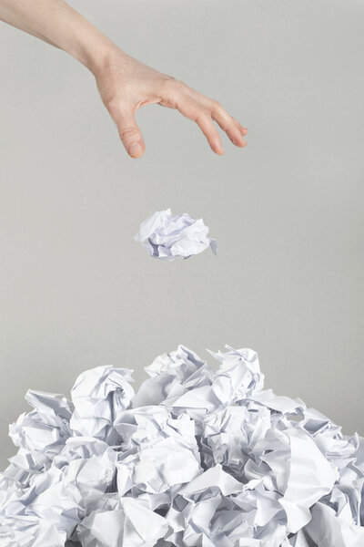 Stack of crumpled paper balls and hand