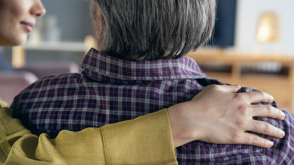 Comforting hand on shoulder of man