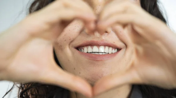 Stock image Woman smiling and making heart shape with her hands