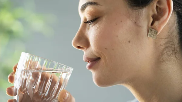 若い女性がコップ一杯の水を飲み — ストック写真