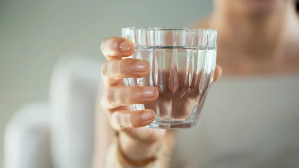 若い女性がコップ一杯の水を飲み — ストック写真