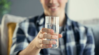 Genç adam bir bardak su içiyor.