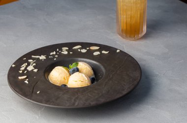 Bir tabak dondurma kepçesi, fotokopi alanı olan üst manzara. Vanilya Dondurması Kreplerinin Kapalı Durgun Yaşamını Gri arka planda Modern Siyah Tabakta Yabanmersini ile Kapatın