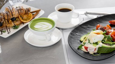 Bir fincan matcha latte ve kahve. Yüksek kalite fotoğraf. Matcha, fincanda yeşil çay latte ve kruvasan. Gri arka plan. Kapatın. Üst görünüm.