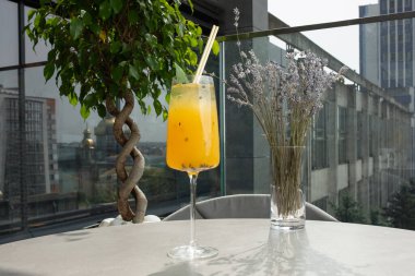 Sarı limon ve tutkulu meyve kokteyli bardakta. Parlak bir zemin üzerinde kurumuş ananas ve nane ile süslenmiş..