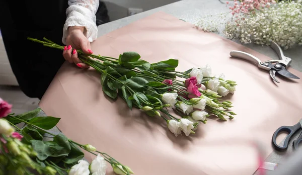 一个女花匠把漂亮的花束包在桌上 桌上的顶部视图 高质量的照片 — 图库照片