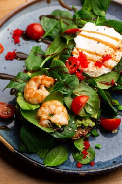 Haşlanmış yumurtalı karabuğday ekmeği tostu, dilimlenmiş avokado, karides, domates ve marul. Beslenme menüsü. Düz yatıyordu