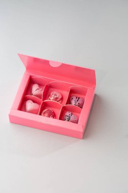 Pembe kutuda, koyu arka planda izole edilmiş lüks el yapımı çikolata şekeri. Özel el yapımı bir bonbon. Pasta dükkanı için ürün reklamcılığı konsepti