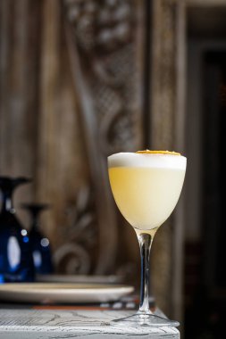 Sarı limon kokteyli ile süslenmiş cam ananas ve nane ile bulanık tezgah arka planında.