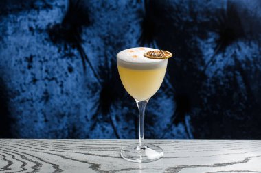 Sarı limon kokteyli ile süslenmiş cam ananas ve nane ile bulanık tezgah arka planında.