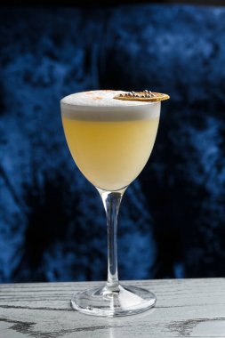 Sarı limon kokteyli ile süslenmiş cam ananas ve nane ile bulanık tezgah arka planında.