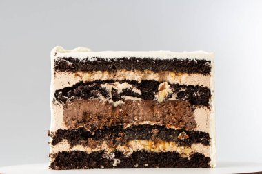 Beyaz arka planda, tatlı bir pasta ikiye bölünür, pasta ikiye bölünür, dolgu ve bisküviler görünür hale gelir. Ürünlerin katalog tanıtımı. Minimalist stil. Boşluğu kopyala