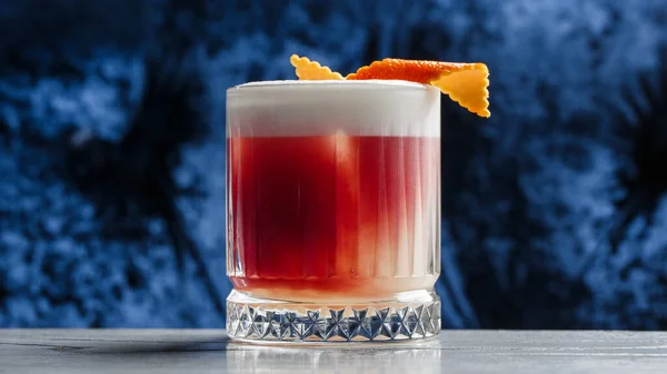 Klassisk Gammeldags Rød Cocktail Retroglass Med Appelsinskall Blå Bakgrunn Sett – stockfoto