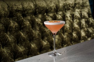 Orange Clover Club Kokteyl in Coupe Glass Köpük tabaka ve turuncu cips ile koyu arka planda izole edilmiş Garnish