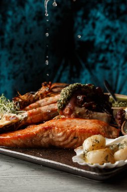 Kızarmış karışık deniz ürünleri midye, karides, somon, kalamar mürekkep balığı ve baharatlı acılı balık sarımsağı. Deniz ürünleri ve et tabağı..