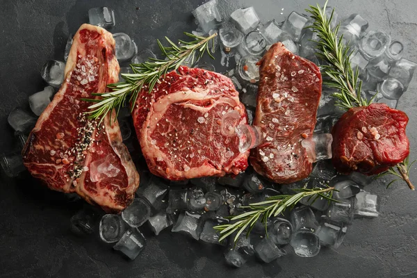 Koyu taşlı tahtada çiğ domuz eti ve baharat. Üst Manzara. Çiğ et, biber, otlar, sarımsak. Mesaj için yer var. Biftek pişirmeye hazır. İçindekiler.