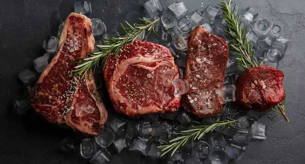 Rauwe Delen Van Varkensvlees Het Donkere Stoned Bord Met Kruiden Stockafbeelding