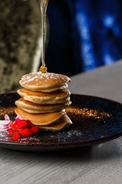 Kahveyle izole edilmiş siyah tabakta böğürtlen ve akçaağaç pekmezli Amerikan gözlemeleri. kafe menüsü.