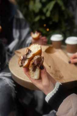 Alman çörekleri. Kadın ellerinde dolgu ve krema şekerli berber. Çikolata ve reçelli çörekleri seven kızlar.