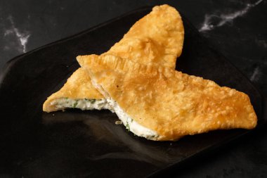 Özbek doğu Tatar mutfağı, süluguni peynirli cheburek kara tahta. Cheburek, kızarmış turta. Geleneksel Türk ve Moğol yemeği