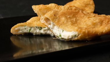 Özbek doğu Tatar mutfağı, süluguni peynirli cheburek kara tahta. Cheburek, kızarmış turta. Geleneksel Türk ve Moğol yemeği