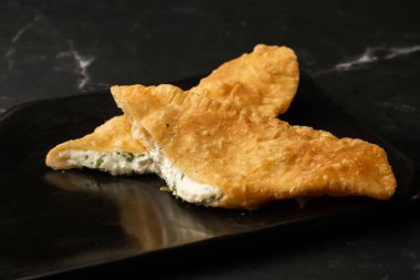 Özbek doğu Tatar mutfağı, süluguni peynirli cheburek kara tahta. Cheburek, kızarmış turta. Geleneksel Türk ve Moğol yemeği