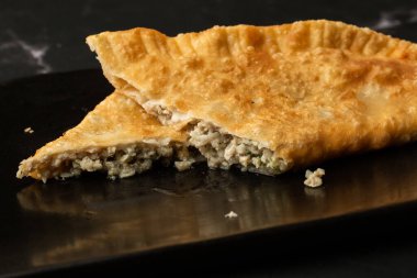 Özbek doğu Tatar mutfağı, kara tahtada çeburek. Cheburek, etli ve soğanlı kızarmış turta. Geleneksel Türk ve Moğol yemeği, börekler börek böreği