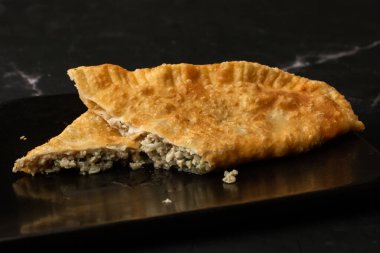 Özbek doğu Tatar mutfağı, kara tahtada çeburek. Cheburek, etli ve soğanlı kızarmış turta. Geleneksel Türk ve Moğol yemeği, börekler börek böreği