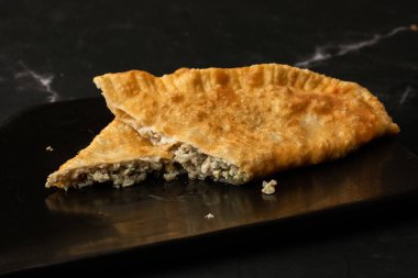 Özbek doğu Tatar mutfağı, kara tahtada çeburek. Cheburek, etli ve soğanlı kızarmış turta. Geleneksel Türk ve Moğol yemeği, börekler börek böreği