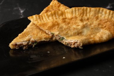 Özbek doğu Tatar mutfağı, kara tahtada çeburek. Cheburek, etli ve soğanlı kızarmış turta. Geleneksel Türk ve Moğol yemeği, börekler börek böreği