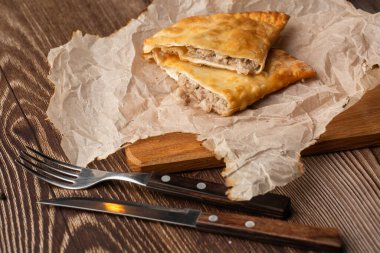 Özbek doğu Tatar mutfağı, tahtanın üzerinde çeburek. Cheburek, etli kızarmış turta. Geleneksel Türk ve Moğol yemeği, börekler börek böreği