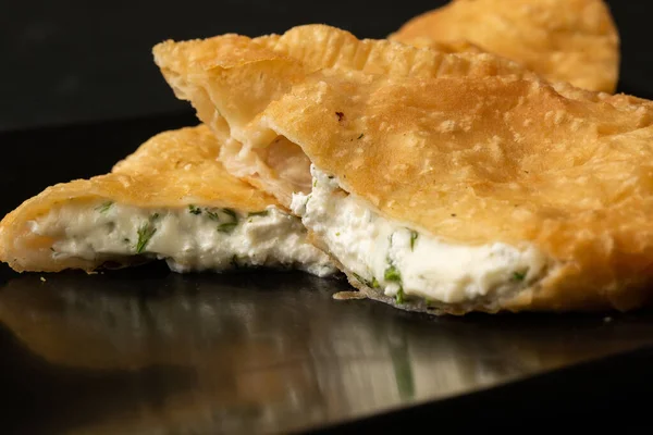 Özbek doğu Tatar mutfağı, süluguni peynirli cheburek kara tahta. Cheburek, kızarmış turta. Geleneksel Türk ve Moğol yemeği