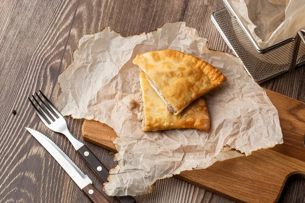 Özbek doğu Tatar mutfağı, tahtanın üzerinde çeburek. Cheburek, etli kızarmış turta. Geleneksel Türk ve Moğol yemeği, börekler börek böreği