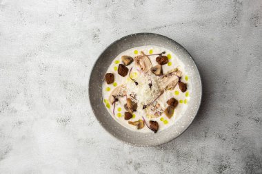 Bir kase mantar kremalı çorba, kızarmış şampiyonlar ve gri mermer arka planda tavuk. Kış, sonbahar sıcak çorba konsepti.