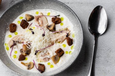 Bir kase mantar kremalı çorba, kızarmış şampiyonlar ve gri mermer arka planda tavuk. Kış, sonbahar sıcak çorba konsepti.