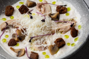 Bir kase mantar kremalı çorba, kızarmış şampiyonlar ve gri mermer arka planda tavuk. Kış, sonbahar sıcak çorba konsepti.