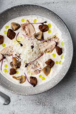 Bir kase mantar kremalı çorba, kızarmış şampiyonlar ve gri mermer arka planda tavuk. Kış, sonbahar sıcak çorba konsepti.