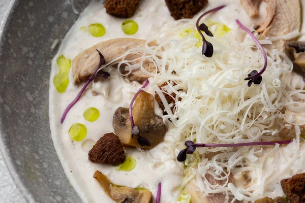 Bir kase mantar kremalı çorba, kızarmış şampiyonlar ve gri mermer arka planda tavuk. Kış, sonbahar sıcak çorba konsepti.