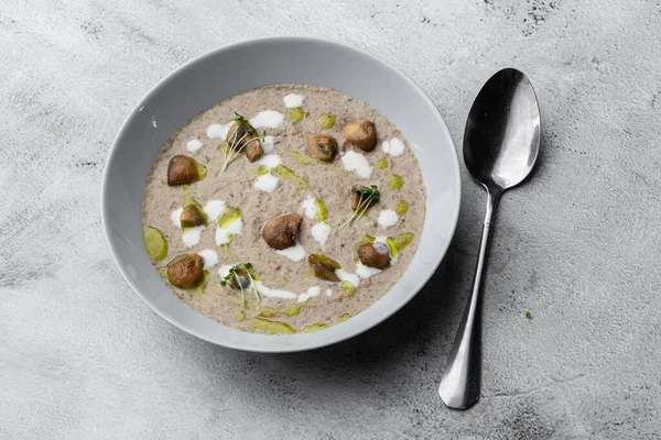 Gri mermer arka planda kızarmış şampiyonlarla bir kase mantar kremalı çorba. Kış, sonbahar sıcak çorba konsepti.