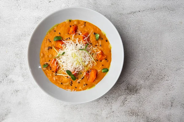 Kremalı, ipeksi domatesli ve parmesanlı geleneksel balkabağı çorbası. Mermer arka plan. Uzayı kopyala Üst görünüm.