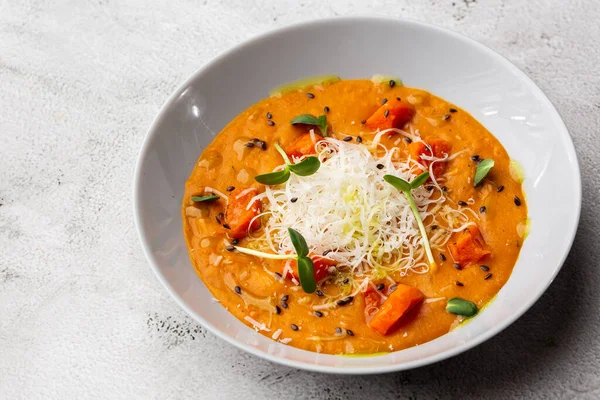 Kremalı, ipeksi domatesli ve parmesanlı geleneksel balkabağı çorbası. Mermer arka plan. Uzayı kopyala Üst görünüm.