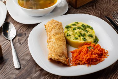 Ukrayna iş yemeği menüsü. Sıcak patates püresi, tavuk çorbası ve kalın gözleme ile servis edilen kızarmış domuz pirzolası.