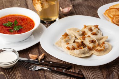 Geleneksel Ukrayna yemeği vareniki ve borş grev otu ve ekşi krema ile servis edilir. Geleneksel Ukrayna yemeklerine yakın görüş.