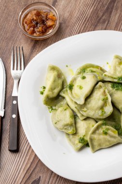 Geleneksel Ukrayna yemeği vareniki, içinde fesleğen ve fesleğen sosu olan bir kasede servis edilir. Geleneksel Ukrayna yemeklerine yakın görüş