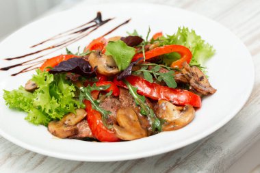 Marullu dana salatası, kırmızı biber ve ahşap arka planda beyaz tabakta mantar, kopyalama alanı. Restoran yemekleri, kapatın. Et salatası..