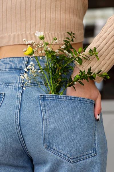 Vrouw Met Mooie Zachte Bloemen Achterzak Van Jeans Vrouw Steekt — Stockfoto